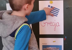 Radek wskazuje flagę Grecji.
